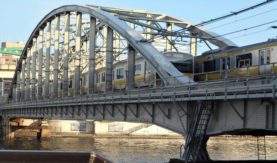 上下線の総武線列車が橋の上で行きかう画像